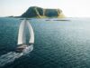 Vision 484: New 48ft Bluewater Catamaran Lands in 2027 Render of the Vision 484 catamaran under sail off a rocky headland