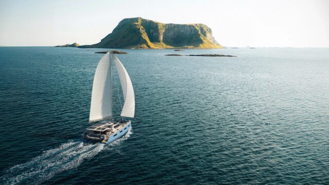 Vision 484 under sail (render) Render of the Vision 484 catamaran under sail off a rocky headland
